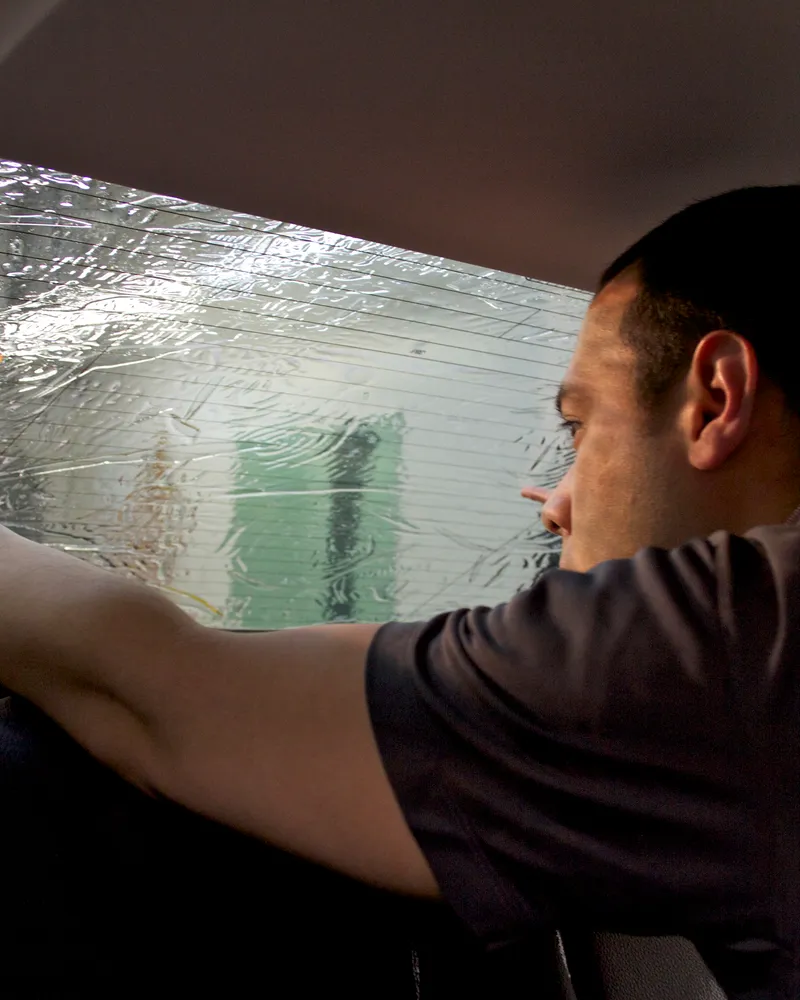 Technician performing detail work inside a vehicle